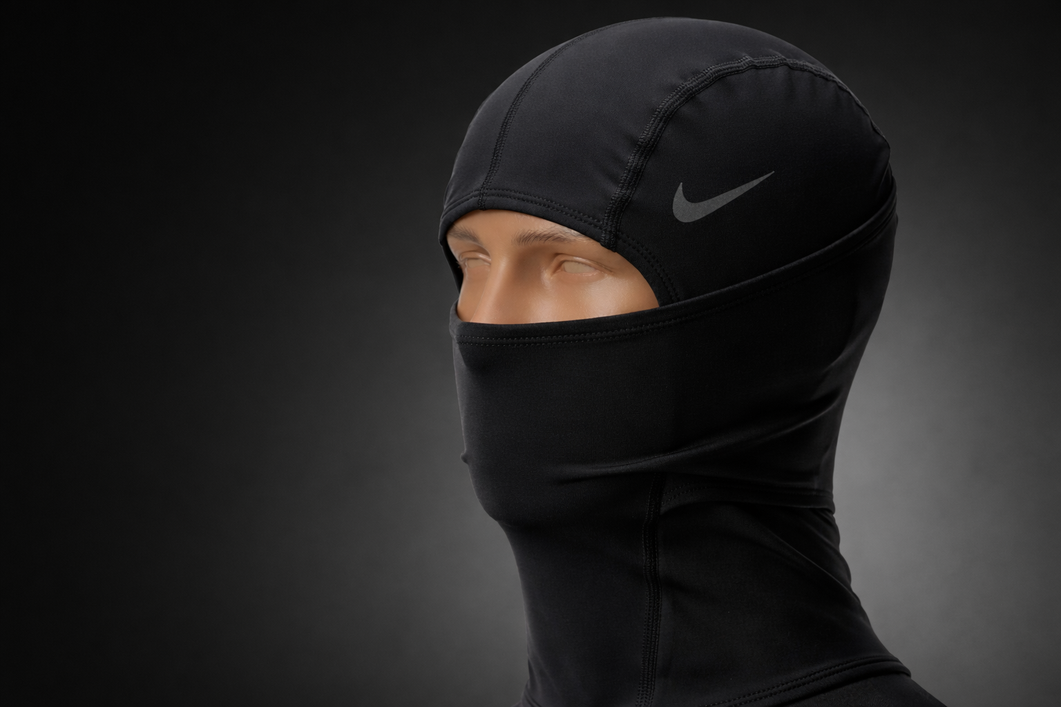 Person wearing a black Nike hood against a dark background